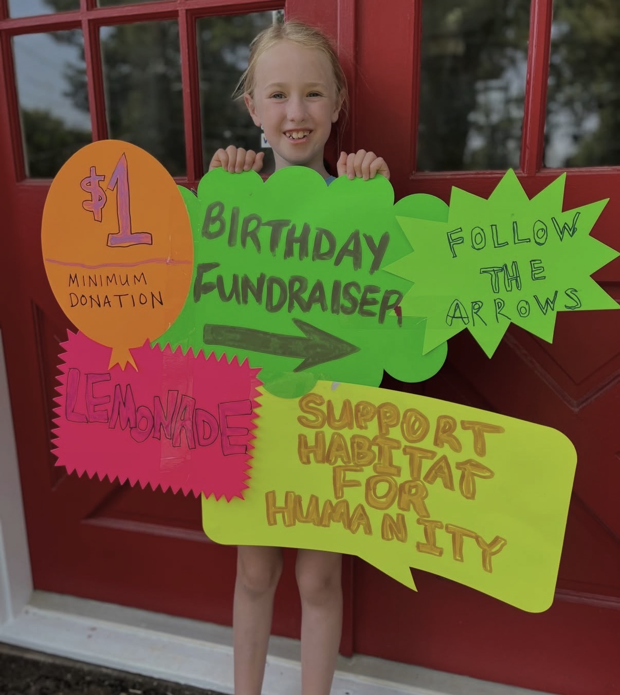 Cora June holds up sign for lemonade stand in past year's fundraiser