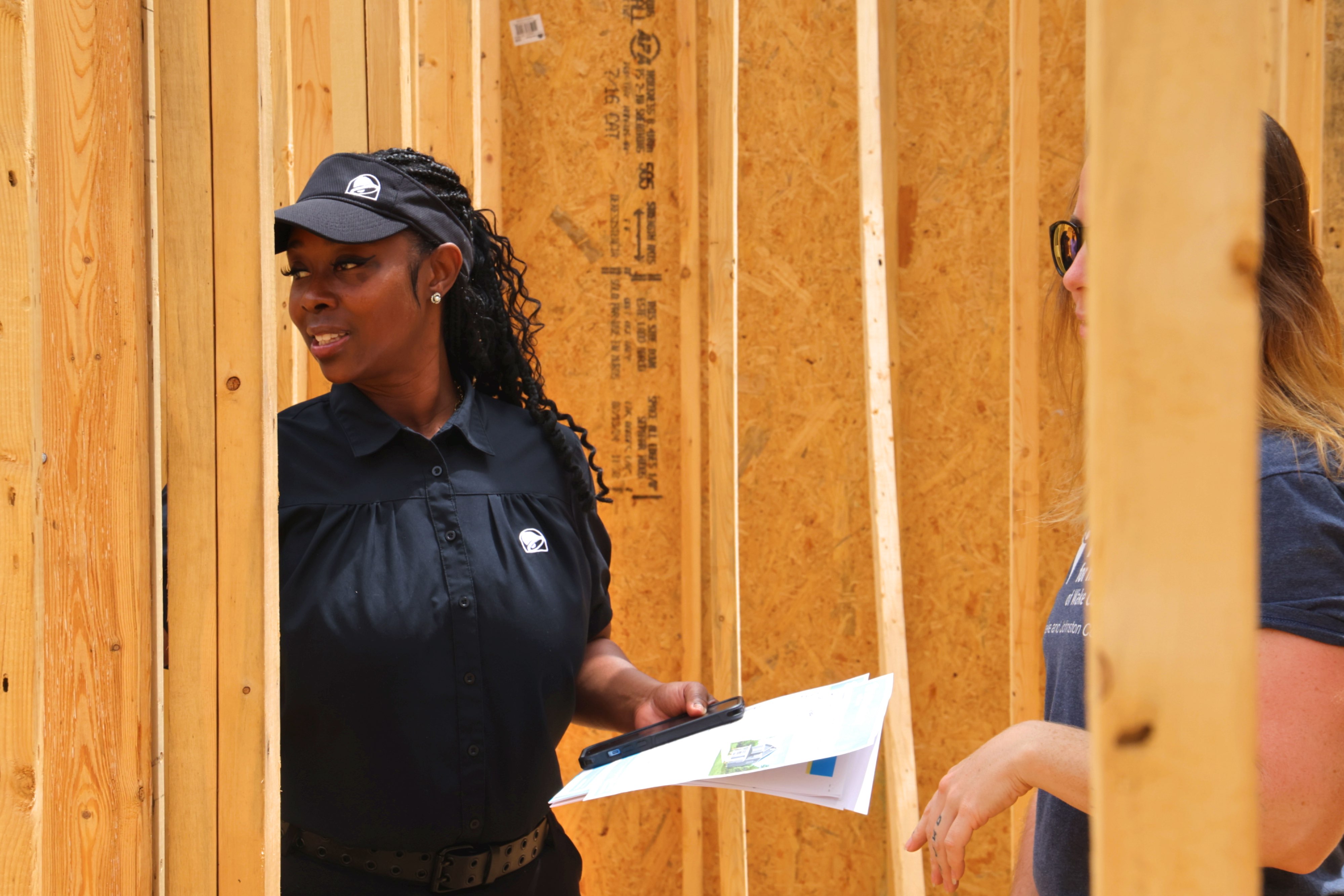 Ayofemi smiles and looks through a home that is currently in construction