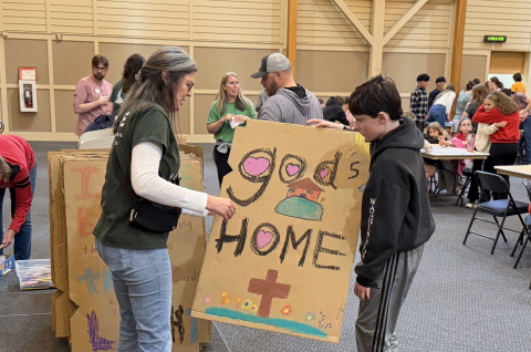 members of St. Francis hold baffle painted at Habitat faith night
